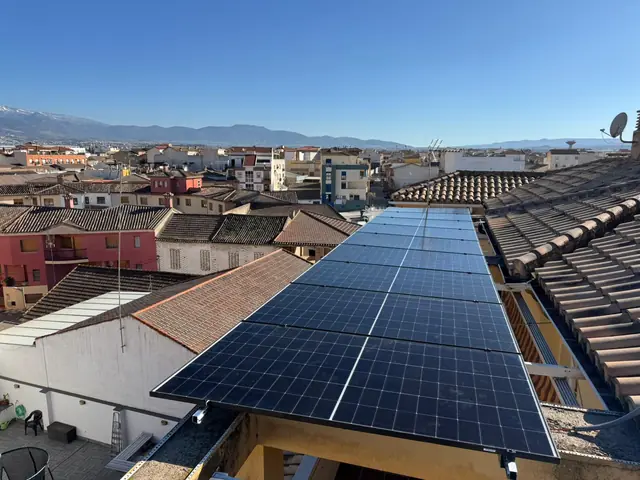 Paneles solares sobre una pérgola, con Sierra Nevada al fondo